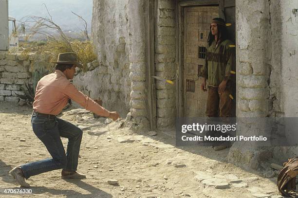 "Italian actor Giuliano Gemma throwing knives at Italian actor Carlo Mucari on the set of the film Tex and the Lord of the Deep. Italy, 1985 "