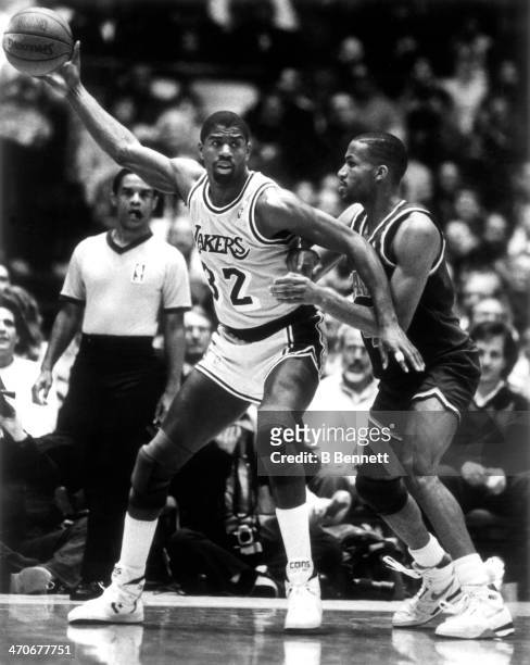 Magic Johnson of the Los Angeles Lakers posts up Ron Harper of the Cleveland Cavaliers during an NBA game circa 1987 at the Forum in Inglewood,...