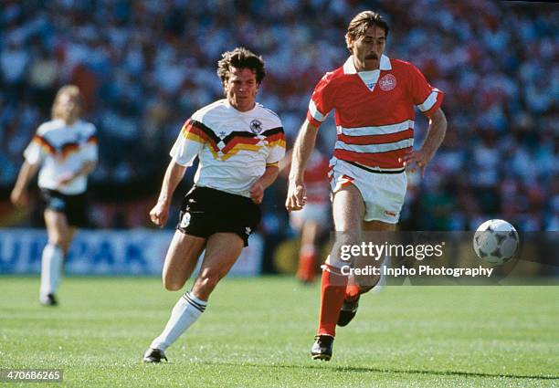 Ivan Nielsen of Denmark reaches the ball ahead of Lothar Matthaus of West Germany during the UEFA European Championships 1988 Group 1 match between...