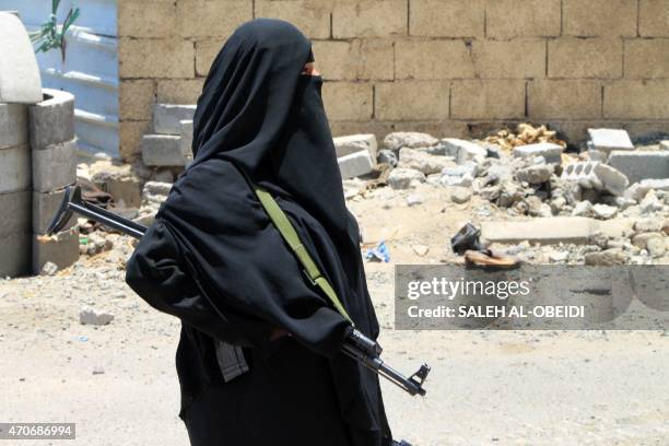 Yemeni woman holds a weapon in the port city of Aden's Dar Saad suburb, on April 22, 2015. Ground fighting between the rebels and forces loyal to...