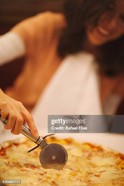 woman slicing pizza - ピザカッター ストックフォトと画像