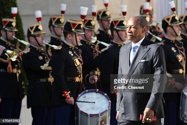 Guinean President Alpha Conde reviews an honor guard prior to a meeting with French President Francois Hollande at the Elysee Palace on April 22,...