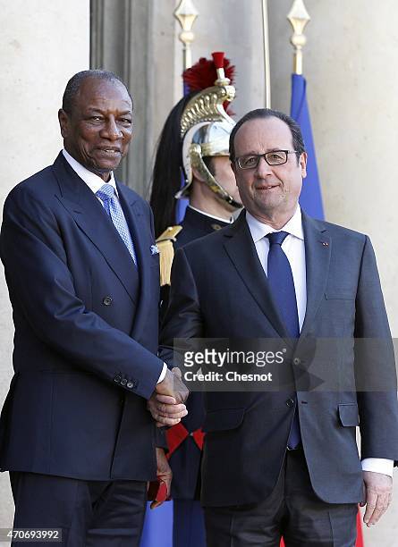 French President Francois Hollande welcomes Guinean President Alpha Conde prior to a meeting at the Elysee Palace on April 22, 2015 in Paris, France.