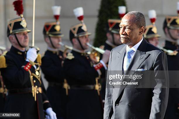 Guinean President Alpha Conde reviews an honor guard prior to a meeting with French President Francois Hollande at the Elysee Palace on April 22,...