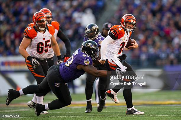 Andy Dalton of the Cincinnati Bengals drops back to avoid a tackle by DeAngelo Tyson of the Baltimore Ravens during the game between the two teams at...