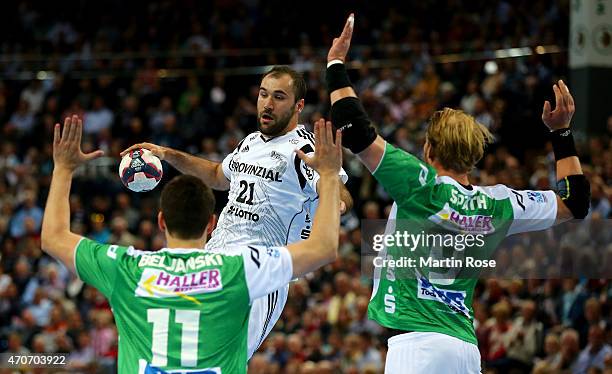 Joan Canellas of Kiel challenges for the ball with Bojan Beljanski and Manuel Spaeth of Goeppingen during the DKB HBL Bundesliga match between THW...