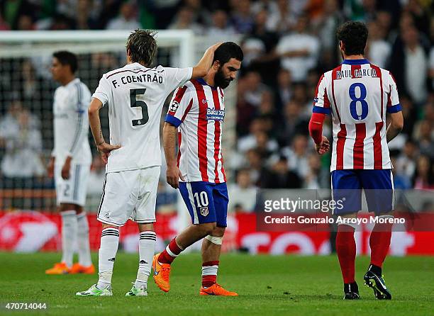 Arda Turan of Atletico Madrid is consoled by Fabio Coentrao of Real Madrid CF as he is sent off during the UEFA Champions League quarter-final second...
