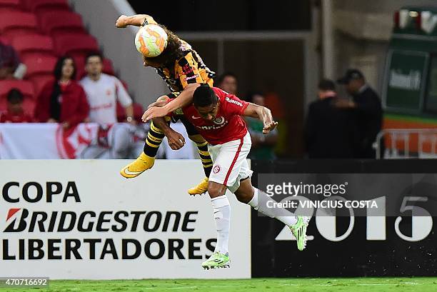 Luis Fernando Martelli of Bolivia's The Strongest jumps for a header with Jorge Henrique of Brazil's Internacional, during the Copa Libertadores 2015...