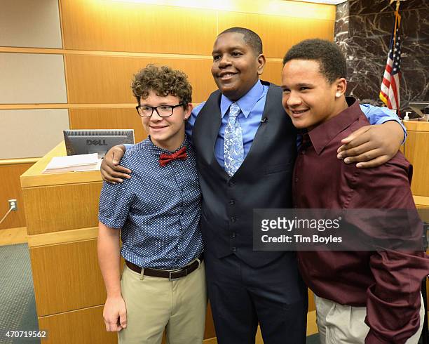 Davion Navar Henry Only poses for a photograph with his new adoptive brother Taylor Going and another friend after being adopted by his former...