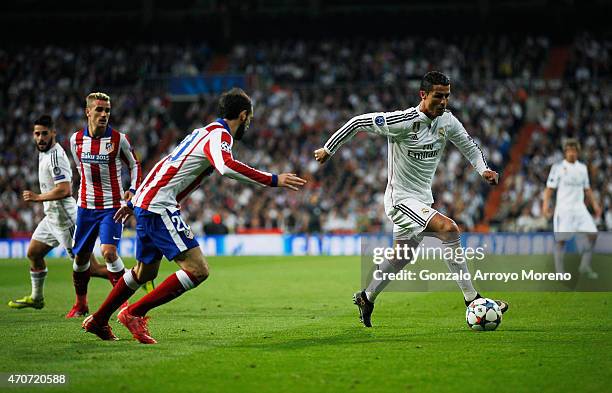 Cristiano Ronaldo of Real Madrid CF is watched by Juanfran of Atletico Madrid during the UEFA Champions League quarter-final second leg match between...