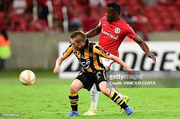 Paulao of Brazil's Internacional vies for the ball with Chamucero, of Bolivia's The Strongest during the Copa Libertadores 2015 football match at...
