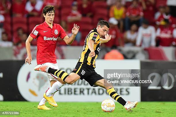 Rodrigo Dourado of Brazil's Internacional vies for the ball with Pablo Escobar, of Bolivia's The Strongest during the Copa Libertadores 2015 football...