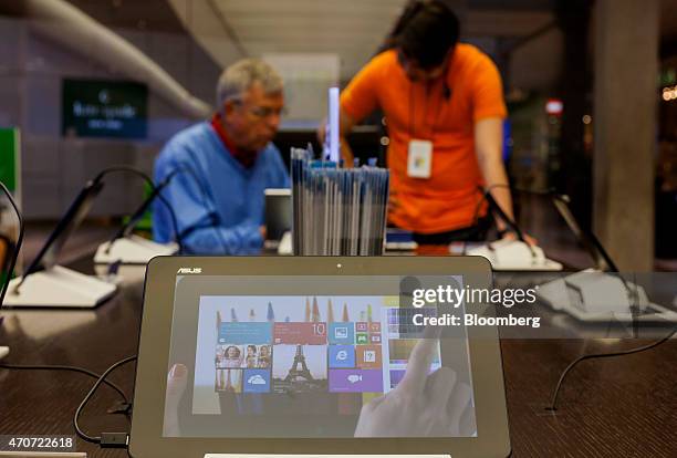 Microsoft Corp. Surface tablet computer is displayed as a sales associate, right, assists a customer at the company's store in Bellevue, Washington,...