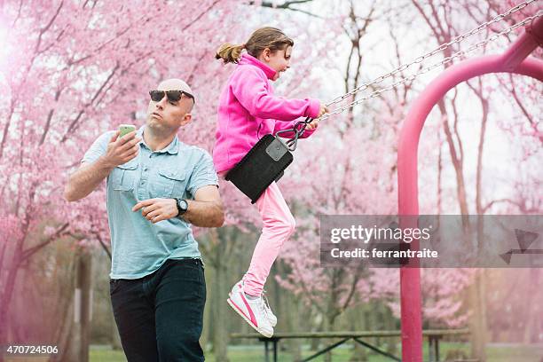 swing accident in the park - funny looking at phone stock pictures, royalty-free photos & images