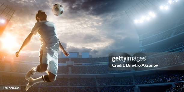 soccer player kicking ball in stadium - voetbal stockfoto's en -beelden