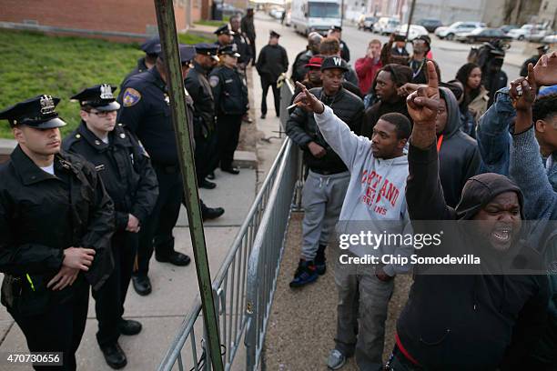 Demonstrators shout at Baltimore Police officers as they stand guard outside the Western District station during a protest against police brutality...