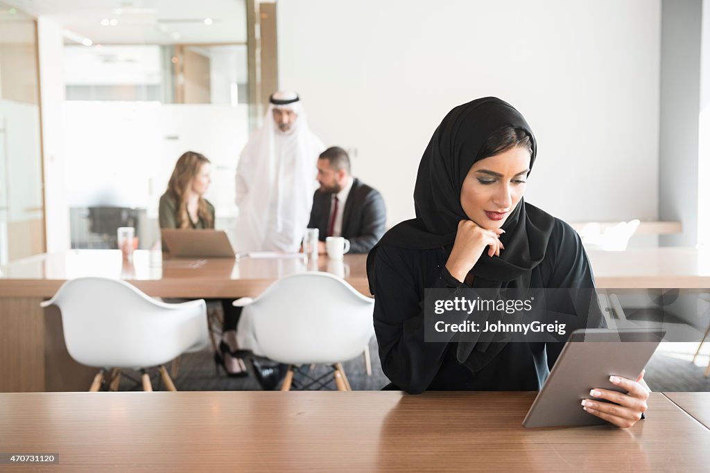 Cándido Retrato de mujer de negocios árabe en el trabajo en oficina moderna