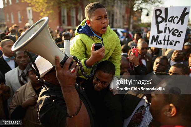 Ten-year-old Robert Dunn uses a megaphone to address hundreds of demonstrators during a protest against police brutality and the death of Freddie...