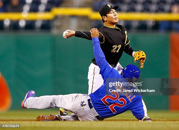 Jung Ho Kang of the Pittsburgh Pirates attempts to turn the double play over Addison Russell of the Chicago Cubs in the fifth inning during the game...