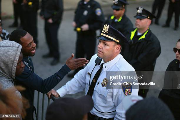 Demonstrators shout at members of the Baltimore Police as they stand guard outside the Western District station during a protest against police...