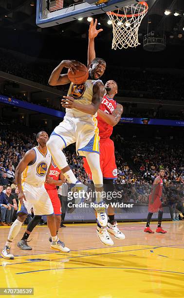 Draymond Green of the Golden State Warriors rebounds against Arnett Moultrie of the Philadelphia 76ers on February 10, 2014 at Oracle Arena in...