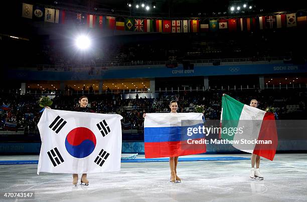 Silver medalist Yuna Kim of South Korea, gold medalist Adelina Sotnikova of Russia and bronze medalist Carolina Kostner of Italy celebrate during the...