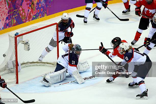 Marie-Philip Poulin of Canada shoots and scores against Jessie Vetter of the United States late in the third period during the Ice Hockey Women's...