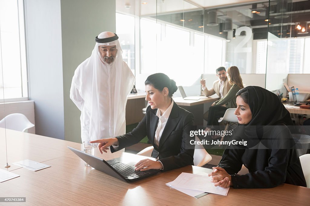 Middle Eastern businesswoman discussing over laptop with team