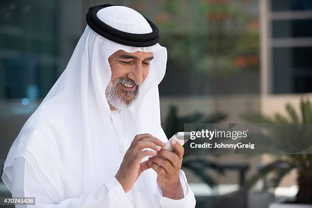 arab man using mobile phone outside office - arab and mobile stock pictures, royalty-free photos & images