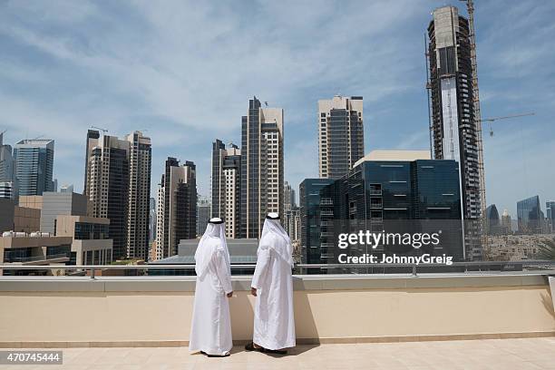arab men look at middle east real estate - dish dash stock pictures, royalty-free photos & images