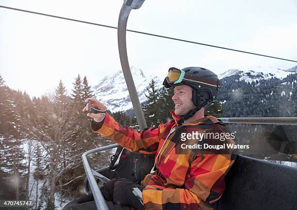 man taking picture of self on ski lift. - ski jacket stock pictures, royalty-free photos & images