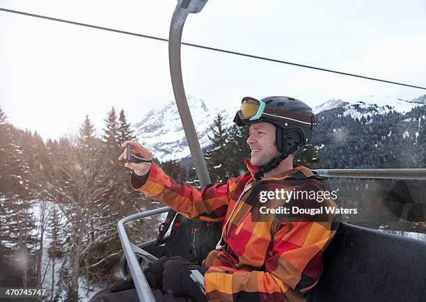 man taking picture of self on ski lift. - ski jacket - fotografias e filmes do acervo