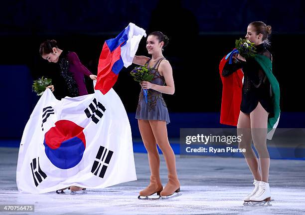 Silver medalist Yuna Kim of South Korea, gold medalist Adelina Sotnikova of Russia and bronze medalist Carolina Kostner of Italy celebrate during the...