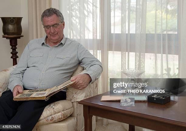 Australia-history-WWI-Gallipoli-graves,FEATURE by Madeleine Coorey This photo taken on April 17, 2015 shows Allan Grant looking at an old scrap book...