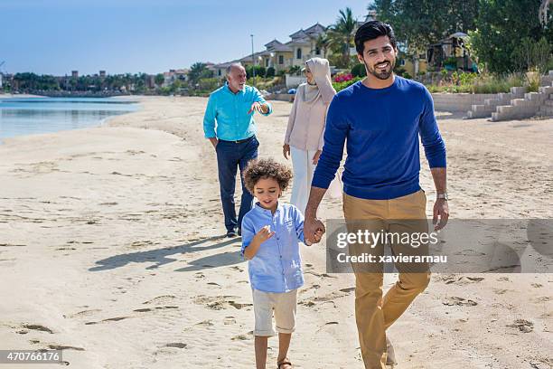 relaxing walk in the beach - arab family stock pictures, royalty-free photos & images