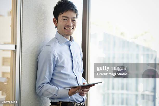 smiling businessman holding digital tablet - 男 ストックフォトと画像