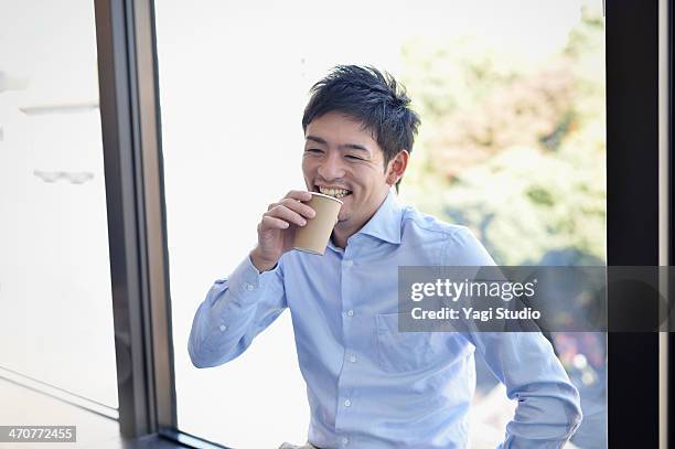 business man drinking coffee in the office - asian young executive laughing office bildbanksfoton och bilder