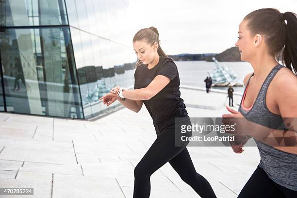 two healthy women ready to start workout in town - climbs to all time high stock pictures, royalty-free photos & images