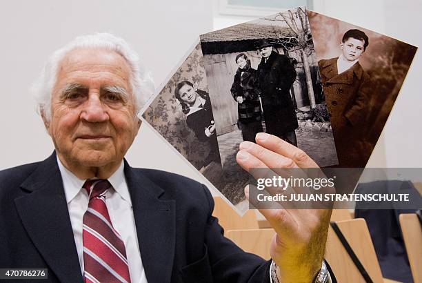 Auschwitz survivor and plaintiff William "Bill" Glied holds photos of his sister Anniko, his parents Marian and Alexander and himself before their...