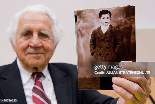 Auschwitz survivor and plaintiff William "Bill" Glied holds a photo of himself before his deportation with his family as part of the Holocaust, as he...