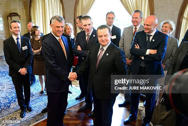 Kosovo's Foreign Minister Hashim Thaci shakes hands with Serbia's Foreign Minister Ivica Dacic during a meeting on improved economic and security...