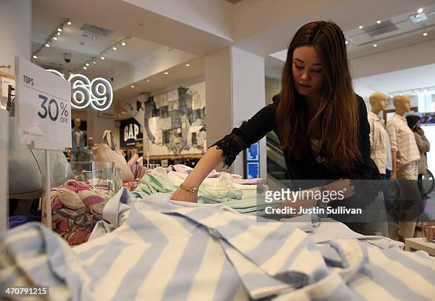 Gap employee Shinju Nozawa-Auclair folds clothes at a Gap store on February 20, 2014 in San Francisco, California. Gap Inc. Announced that they will...