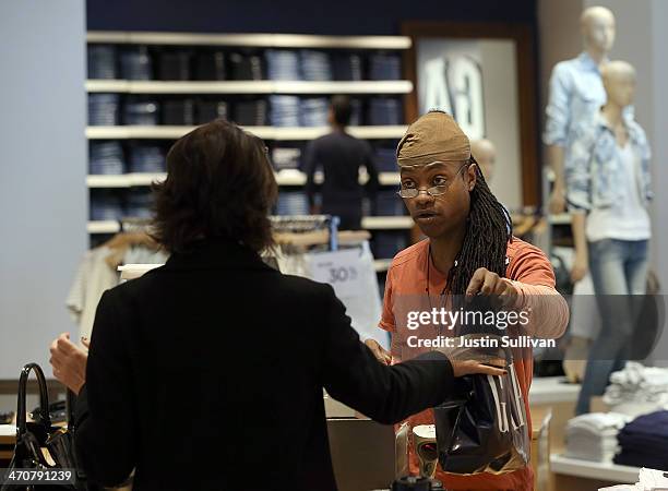 Gap employee Ni'Jean Gibson helps a customer at a Gap store on February 20, 2014 in San Francisco, California. Gap Inc. Announced that they will...