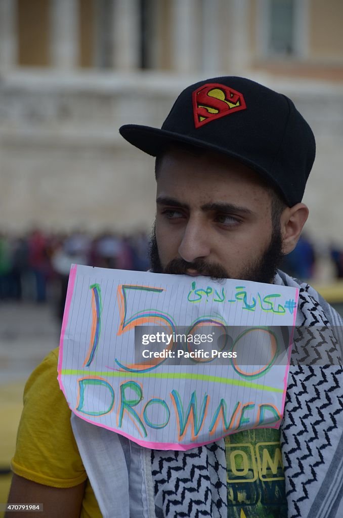 A demonstrator holds a placat with the phrase '1500 drowned...