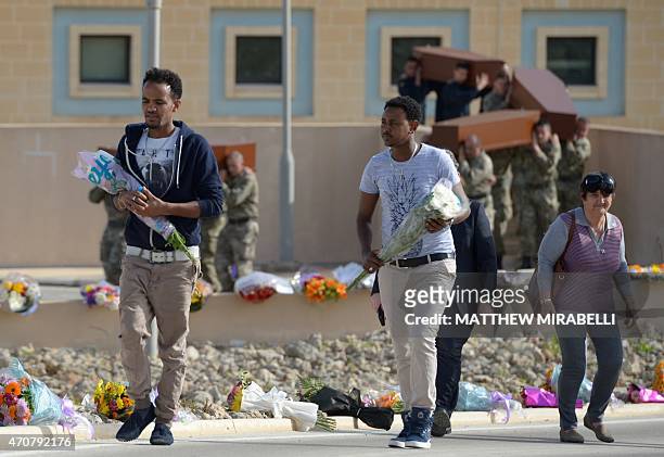 Asylum seekers living in Malta, arrive with flowers to attend an interfaith funeral ceremony of 24 migrants who died after a fishing boat carrying...