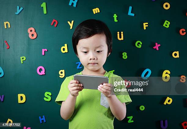 menino usando telefone inteligente - número magnético imagens e fotografias de stock