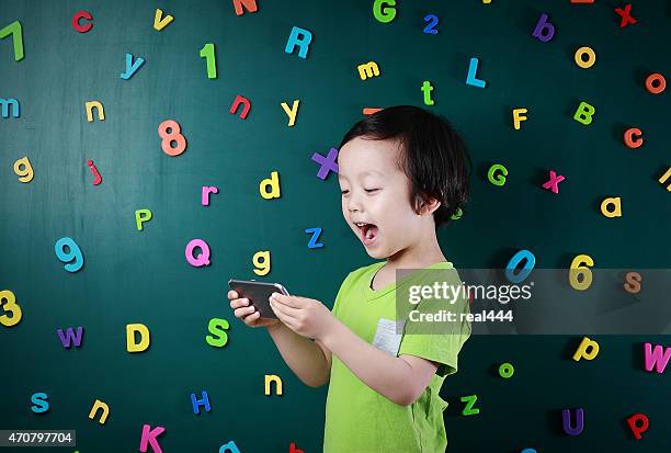 menino usando telefone inteligente - número magnético imagens e fotografias de stock