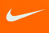 White Nike Logo on Orange Background;Nike, is an American