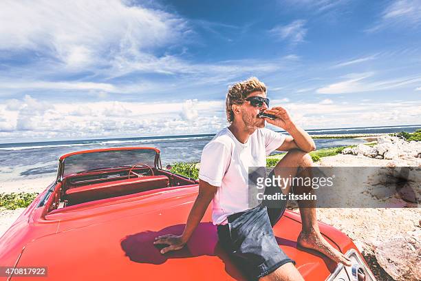 happy young man in convertible car - harmonica stock pictures, royalty-free photos & images