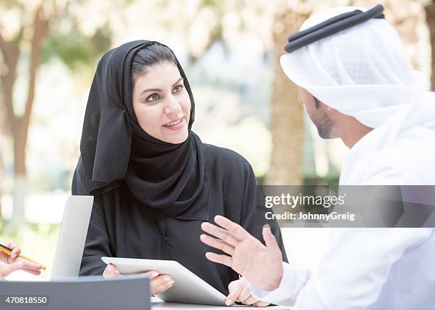 emirati businesswoman in discussion with arab business colleague - ghoutra stock pictures, royalty-free photos & images